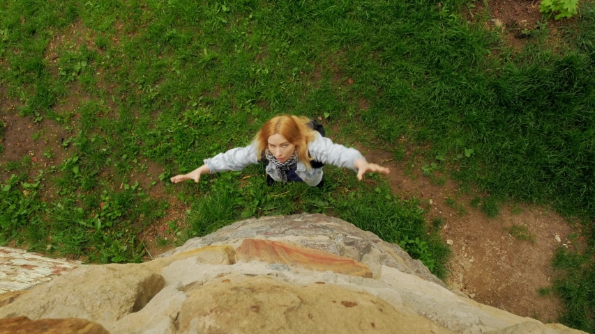 zombie girl tries to climb the stone wall of the castle and bite tourists