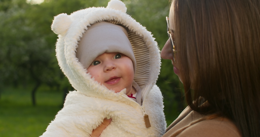 Close-up shooting. The baby is smiling and leaning against his mother. A walk in the Park. 4K