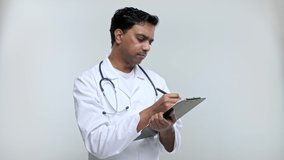 Doctor Writing in clipboard Good Ideas. Indian Man Doctor Clipboard Isolated