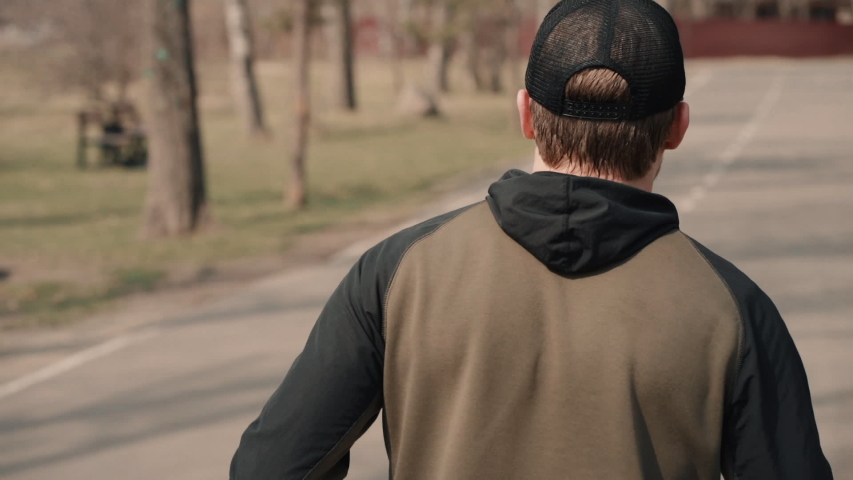 Rear view athletic man jogging on spring morning in public city park to lose weight and stay fit healthy. outdoor running sport traning, endurance training. sport and fitness lifestyle | Shutterstock HD Video #1052921975