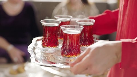 A woman is serving hot tea.Traditional Turkish tea.