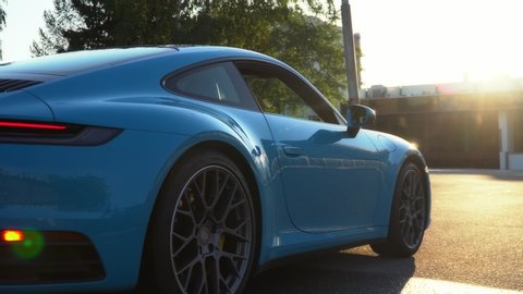 Moscow, Russia 07-02-02019 Porsche 911 Carrera 4S (Miami Blue) 992 Sports car goes away into the distance in the sun and sun rays. A sports car is driving in the Parking lot.