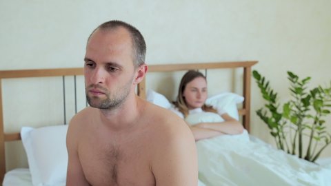 Upset man sitting in bed, sexual problems concept