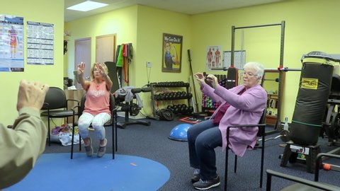 Andover , IL / United States - 12 25 2019: Trainer is coaching a senior woman in dexterity exercises during Rock Steady Boxing class at a studio specializing in Parkinson's Disease symptom management