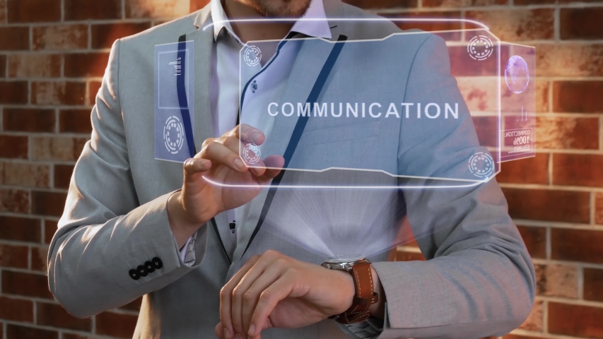 Unrecognizable businessman activates conceptual HUD holograms on smartwatch with text Communication. Man in jacket with holographic technology on wristwatch on background of brick wall - Powered by Shutterstock - Get 15% off with code: PIKWIZARD15