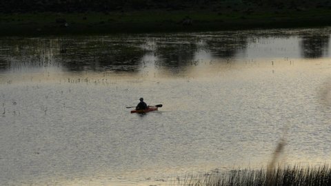 A man fishing from a kayak on a lake