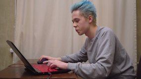 Gamer paying computer onlline video game, laughing, excited gamer with blue hair, clor hair teenager