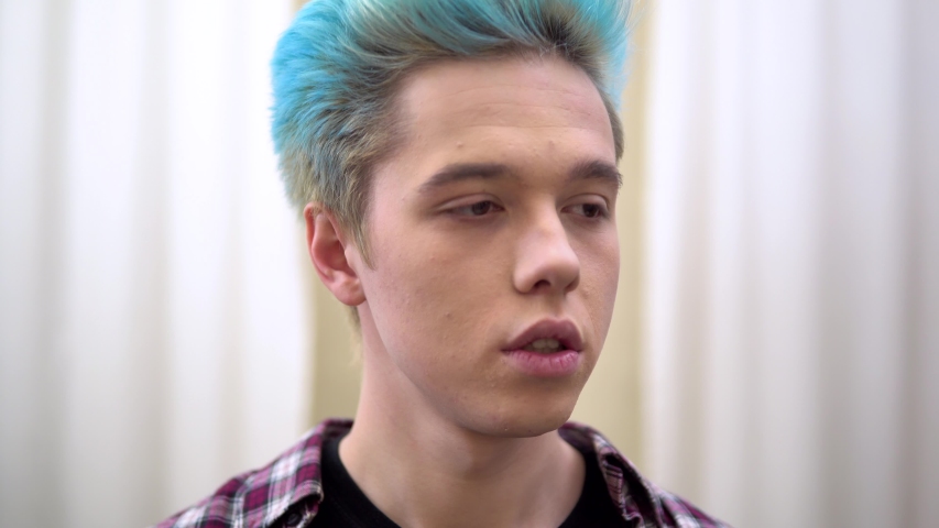 Young man answer to call, speaking by mobile, lookin at sides, face portrait close up