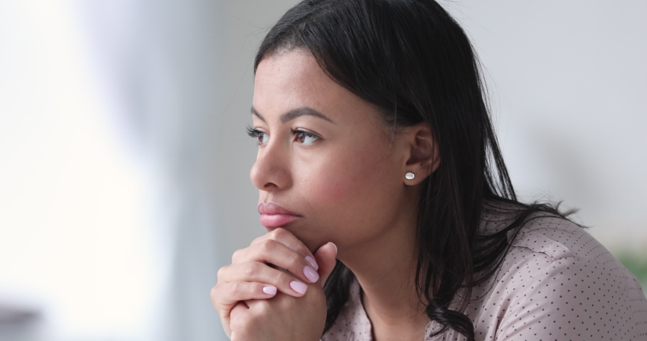 Close up head shot unhappy stressed african american woman thinking of hard decision. Upset frustrated biracial young lady feeling anxious, suffering from mental problem or loneliness at home. | Shutterstock HD Video #1052948837