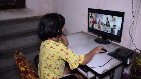 Online Classroom - Indian school girl happy and waving while studying online Class from her home with her desktop.  Distant Learning are happening due to Covid 19 lock down 
India, May 2020
