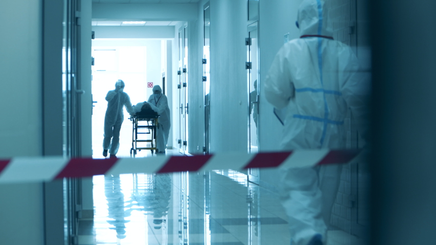 Paramedics are taking a patient through a hall under lockdown. Covid-19 concept. | Shutterstock HD Video #1052956865
