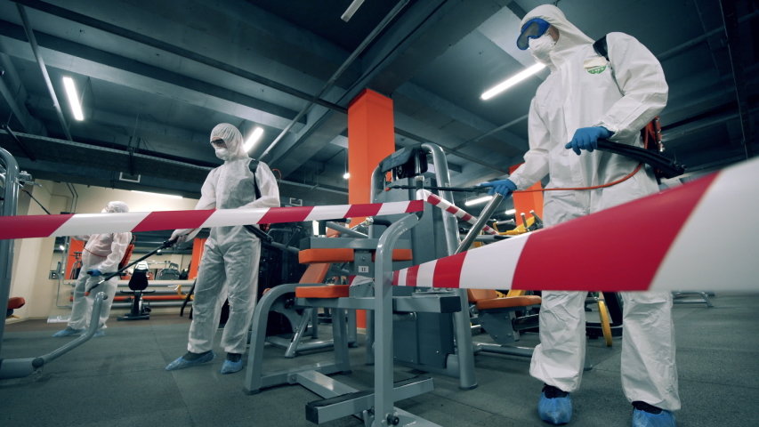 Sanitation experts are disinfecting fitness machines | Shutterstock HD Video #1052956955