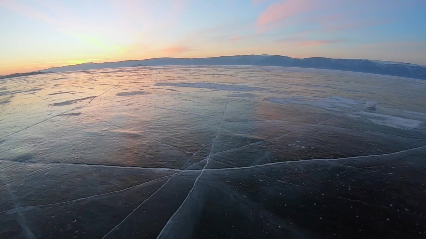Walking on frozen lake under a romantic evening sky.