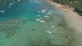 Top drone view of a traditional philippine boats on the surface of the azure water in the lagoon. Seascape with blue bay and boats view from above. Summer and travel vacation concept