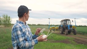 smart farming tech agriculture farming. man farmer engineer studies a wheat crop in a green field using a technology controls a tractor with agricultural machinery. male red worker neck works in a - Powered by Shutterstock - Get 15% off with code: PIKWIZARD15