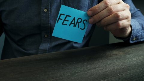 A man burns a sheet with the words fears. Motivational concept video about mental problems.