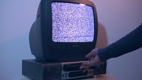 An old 90s TV with a video recorder. Hand inserted VHS into the VCR. The lamp TV stands on a BHS tape recorder and reproduces noise.