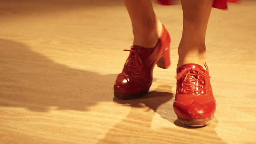 Close up feet of a caucasian woman dancer in a red flamenco dress. Close up feet of a flamenco dancer with red shoes.  Royalty-Free Stock Footage #1052999759