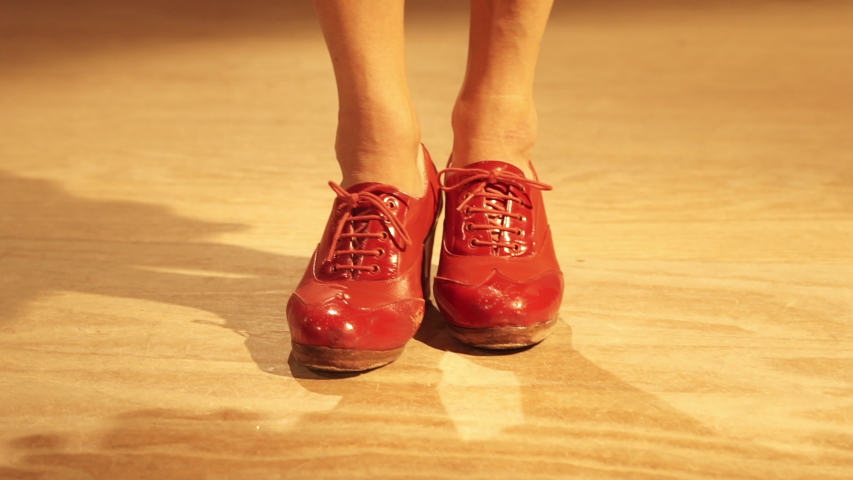 Close up feet of a caucasian woman dancing. Close up red shoes of a flamenco dancer with red shoes dancing inside a studio with wooden floor. Royalty-Free Stock Footage #1052999765