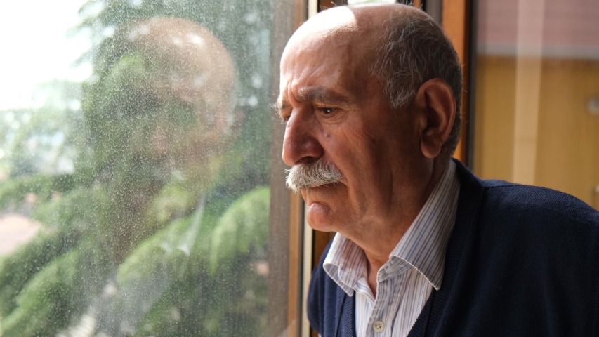 closeup senior man looking to outside from window 4k  Royalty-Free Stock Footage #1053000191