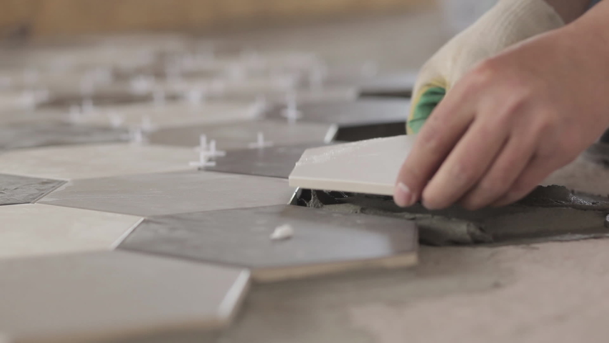 Installing ceramic floor tiles - measuring and cutting the pieces. Construction, renovation, repair apartment. Cuts tile. Tile cutting | Shutterstock HD Video #1053008582