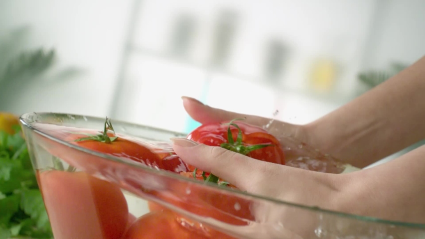 A woman is washing tomatoes in slow motion. Royalty-Free Stock Footage #1053011828
