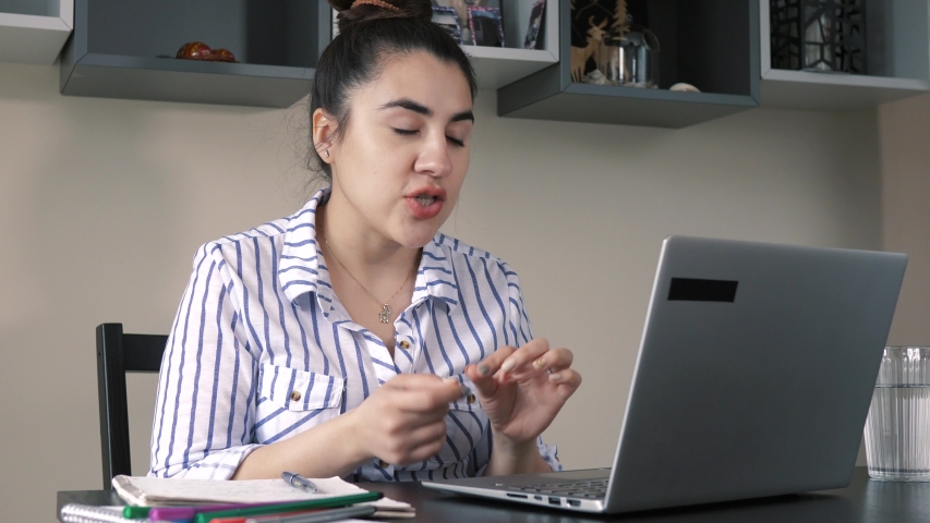 Woman working for home videoconferencing on her laptop computer collaborating with other people. Remote work away from the office concept Royalty-Free Stock Footage #1053017987