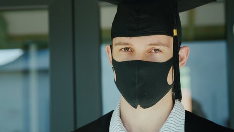 Graduate in a protective mask and cap, graduating from college under quarantine
