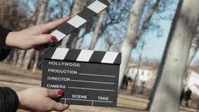 Hands with a movie clapperboard on natura background