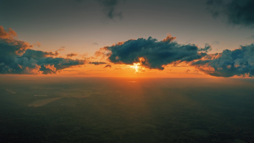 Aerial view of epic dark clouds flying into camera, revealing scenic sunset sun setting into horizon. Timelapse, 4K UHD.	
 Royalty-Free Stock Footage #1053040007