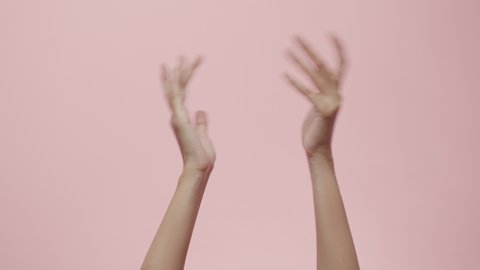 Close up of Woman's hand clapping, celebrating, and applause doing the hand gesture isolated on a pink studio background with copy space for place a text, message for advertisement, and promotional