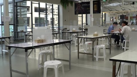 Bangkok,Thailand-May 23,2020:Seat for customers sitting separated in food center with table shield plastic partition to protect infection from coronavirus covid-19, restaurant and social distancing.