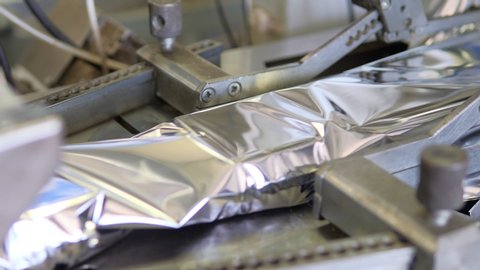 Plastic wrapping machine on production line packs food during coronavirus