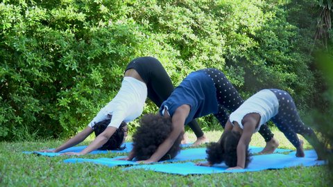 african american single mom teaching two daughter doing yoga together at home outdoor. happy black family funny to workout .
