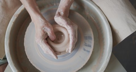 Female potter makes a pot on the pottery wheel. Arkistovideo