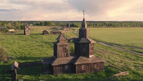 Aerial all-round view of the abandoned wooden church and a  windmill, a farmhouse and a cottages on the background in the deserted outskirts of the village at summer sunset.  - Powered by Shutterstock - Get 15% off with code: PIKWIZARD15