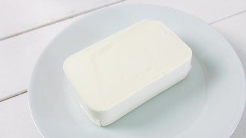 Cutting of tasty feta cheese on plate