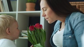 Handheld video of toddler giving flowers to his mother. Shot with RED helium camera in 8K 