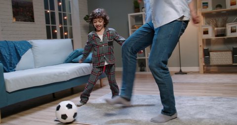 Young asian father and his son with curly hair playing football. Funny man dribbling the ball, enjoying his time together with kid - happy family, recreational pursuit concept 4k footage