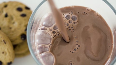 Chocolate milk in slow-motion pouring into a glass. Shot in 4k.