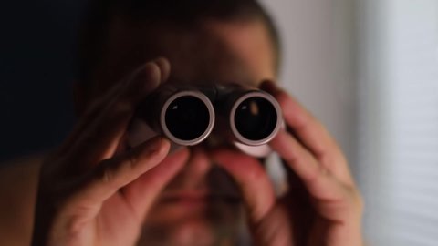 Man spying on people, using binoculars for observation, spying on women, pervert