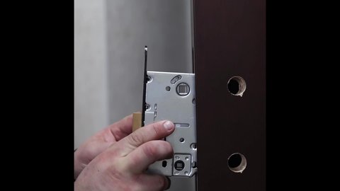 lock repair close up. The master installs a lock in the door