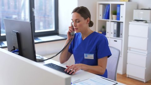 medicine, technology and healthcare concept - female doctor or nurse with computer calling on phone at hospital