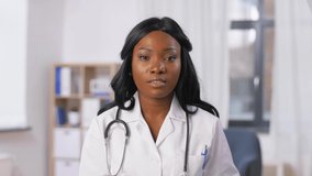 medicine, online service and healthcare concept - african american female doctor having online consultation and showing medicine at hospital