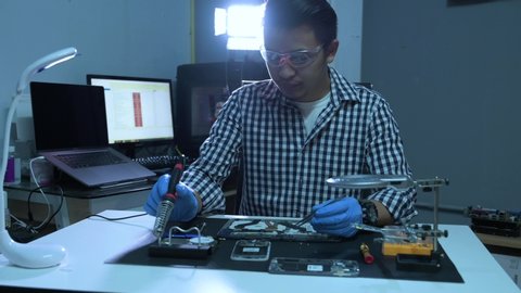 The 4K footage of the technician assembling inside of smartphone by screwdriver in the lab. the concept of computer hardware, mobile phone, electronic, repairing, upgrade and technology.