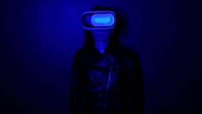 The girl in virtual reality glasses dances like a DJ. Blue light.