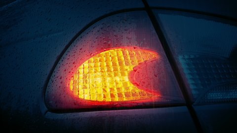 Car Light Flashes In The Rain At Night