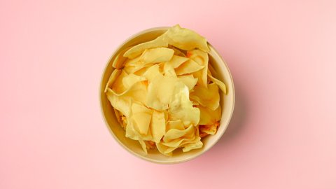 Stop motion of eating Durian chips in a bowl on light pink background, Durian is Thailand fruit , close up top view