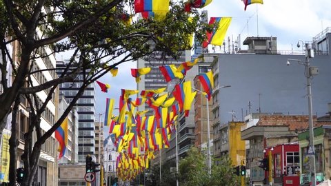 Colombian waving flags in Bogota on a sunny day wide shot in slow motion