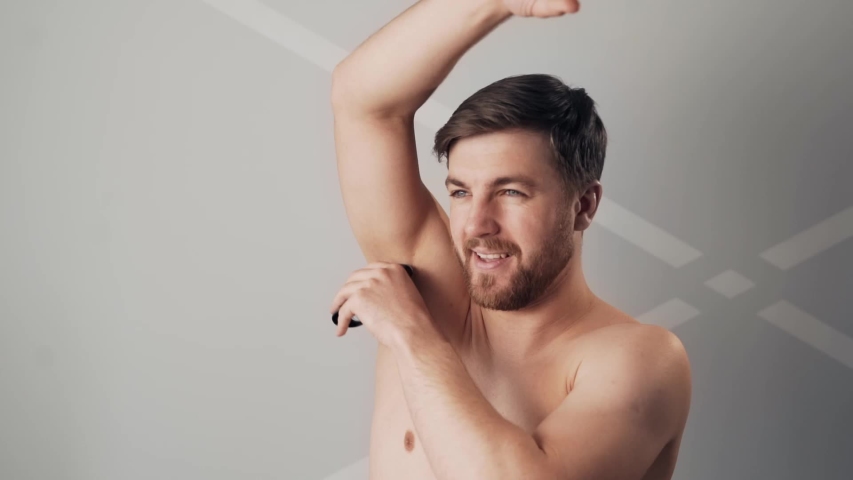 handsome bearded man shaving his armpits